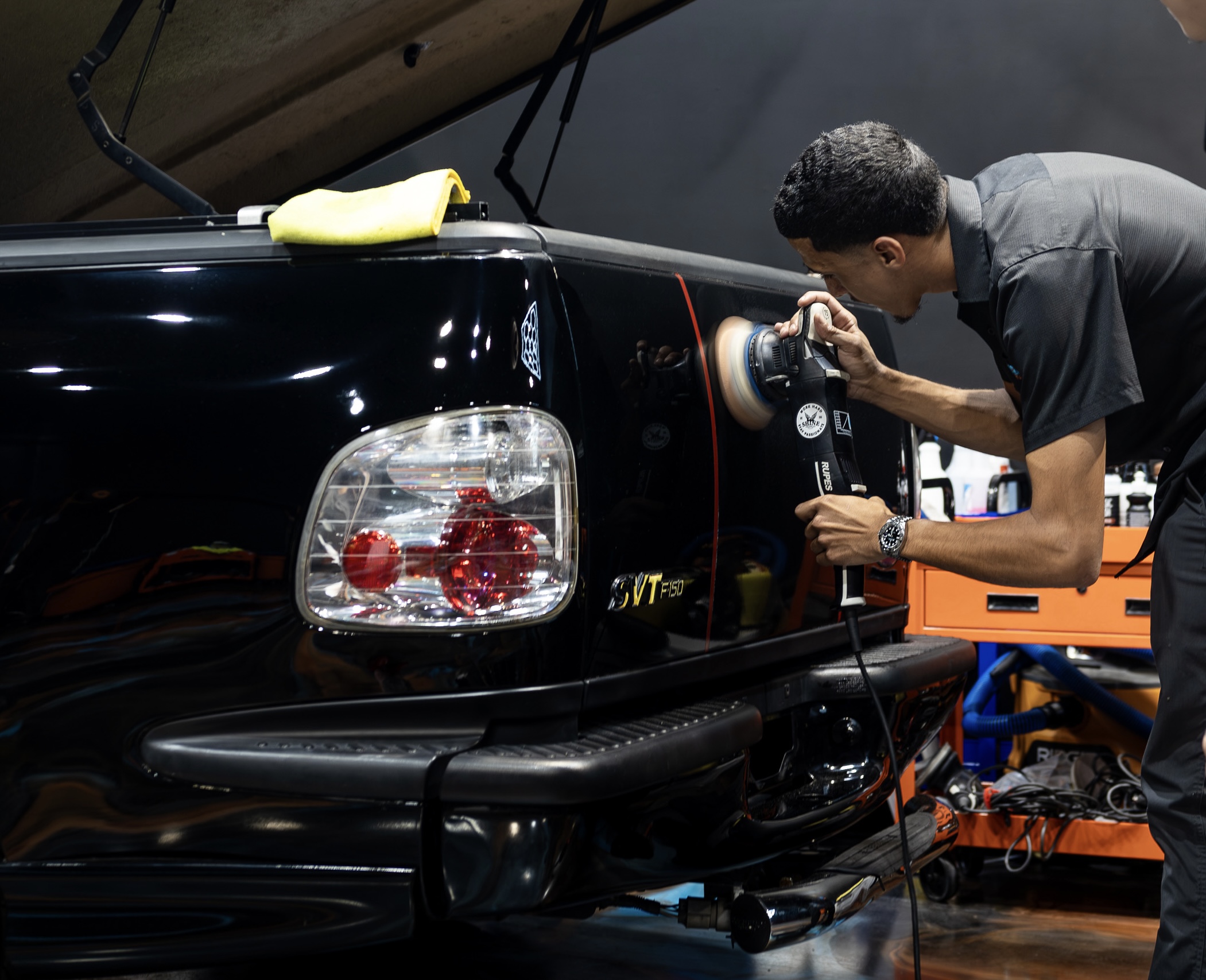 Close view of machine polishing the black Ford SVT Lightning before ceramic coating