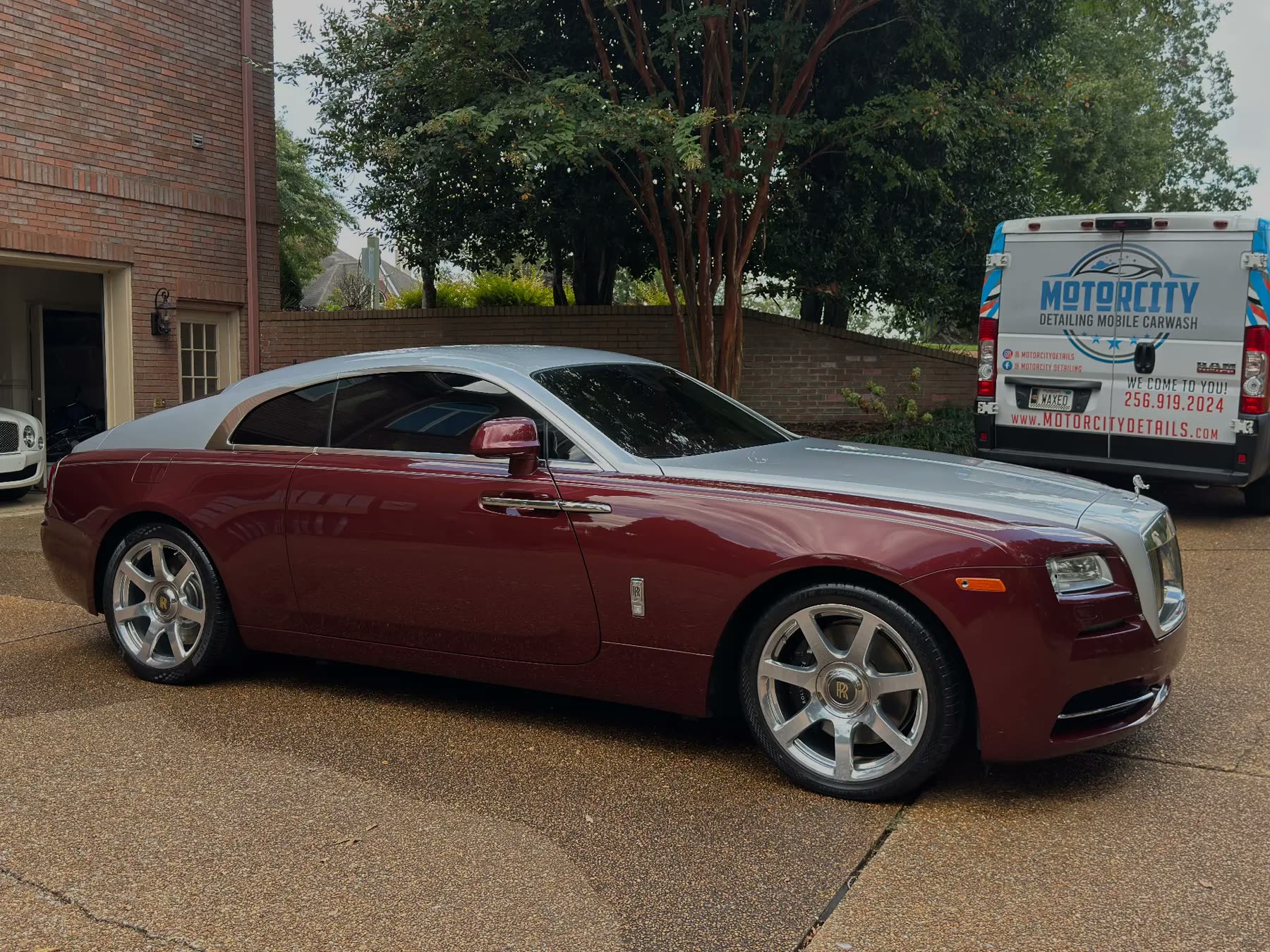 Two-tone Rolls-Royce Wraith detailed in a driveway beside the Motorcity Detailing mobile unit