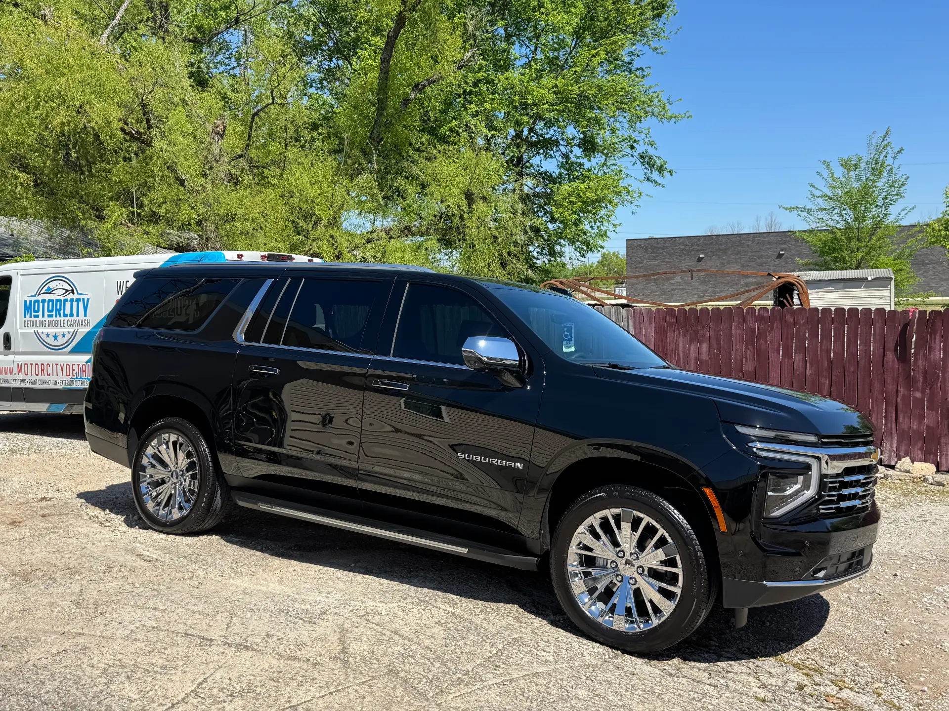 Black Chevrolet Suburban detailed on location beside the Motorcity Detailing mobile unit