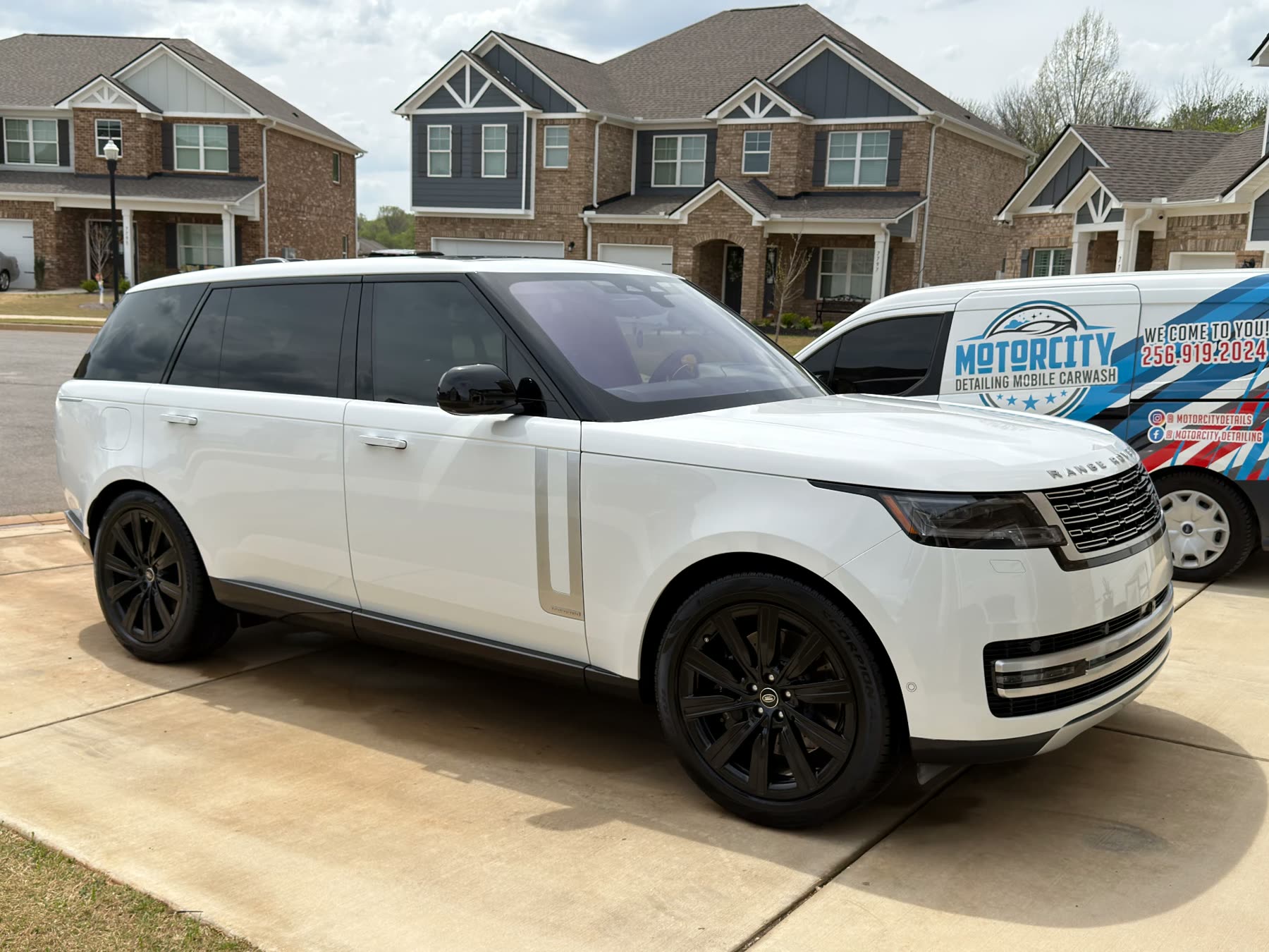 White Range Rover detailed in a driveway beside the Motorcity Detailing mobile unit