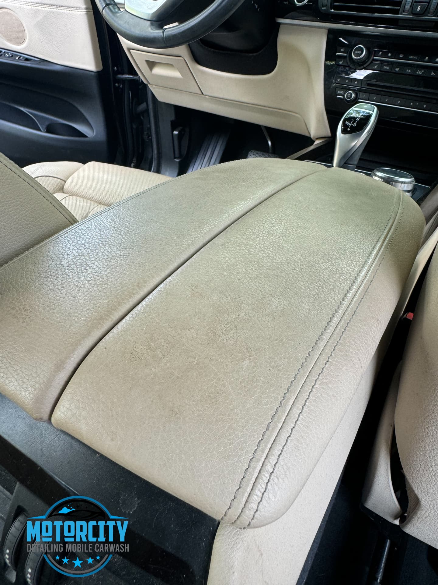 Worn beige leather seat and console before interior cleaning