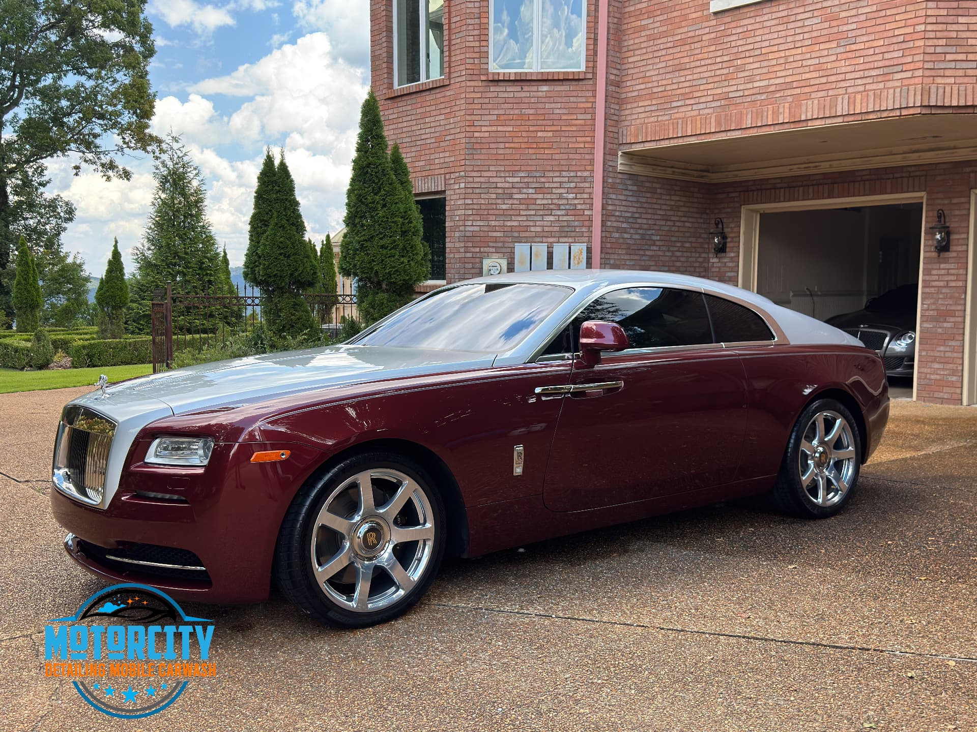 Two-tone maroon and silver Rolls-Royce Wraith detailed in a driveway after a Motorcity Special package