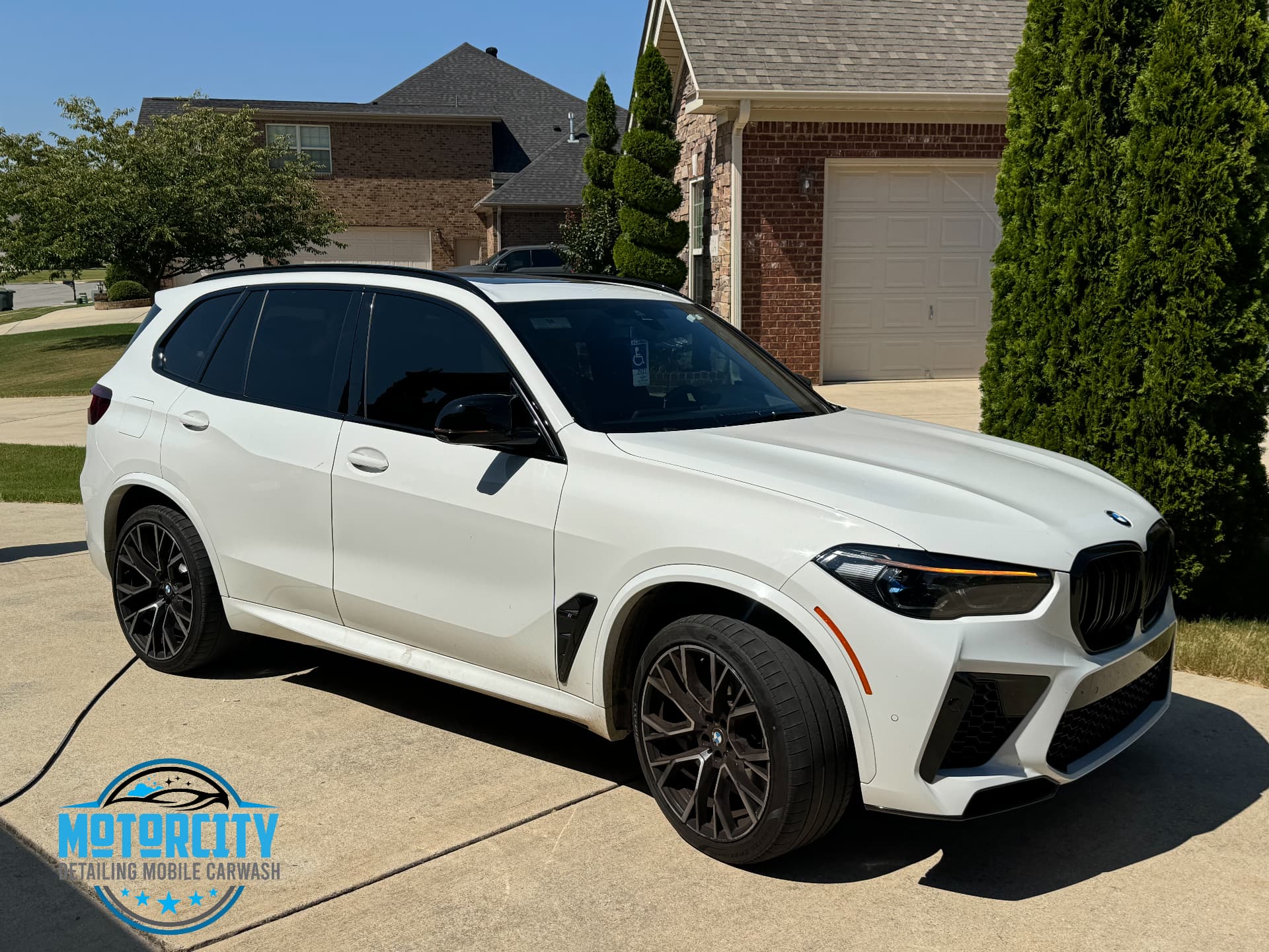 White BMW SUV mid-wash before the exterior wash and wax was completed